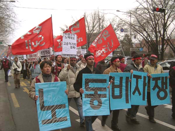 "노동 비자 쟁취"를 외치며 행진하는 집회 참가자들 